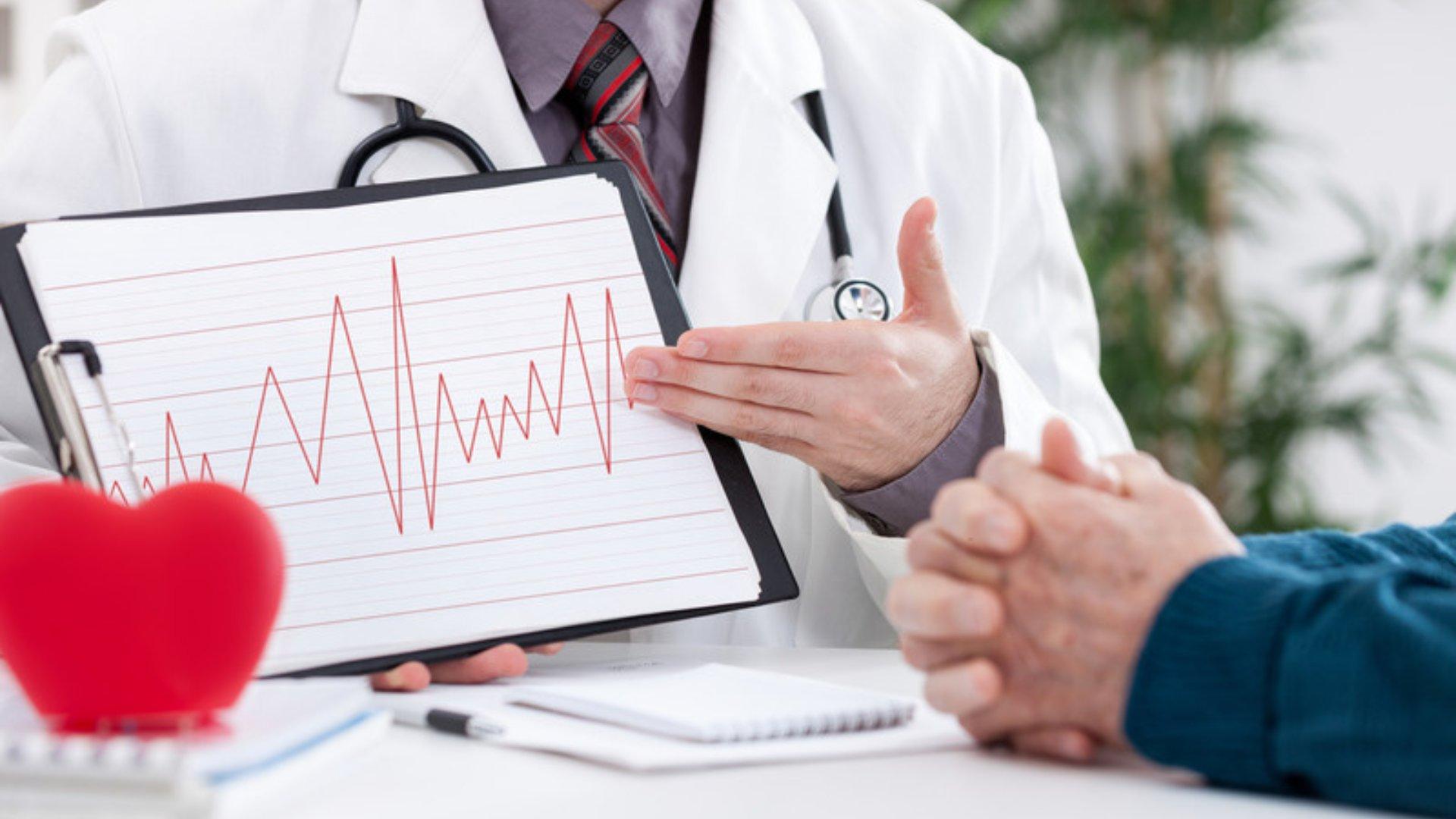 Cardiologo mostra a un paziente il tracciato elettrocardiografico durante una visita cardiologica